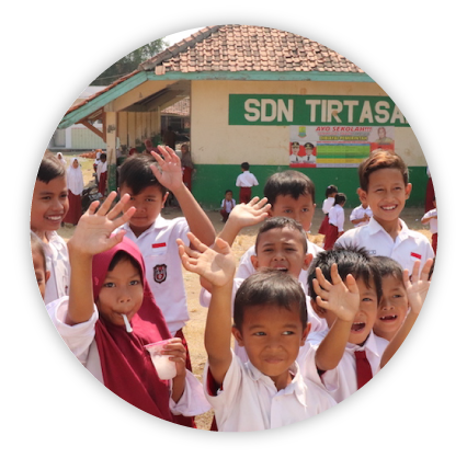 Image of school children waving to the camera outside of class
