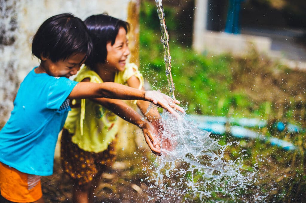 Two children playing in a stream of clean water.